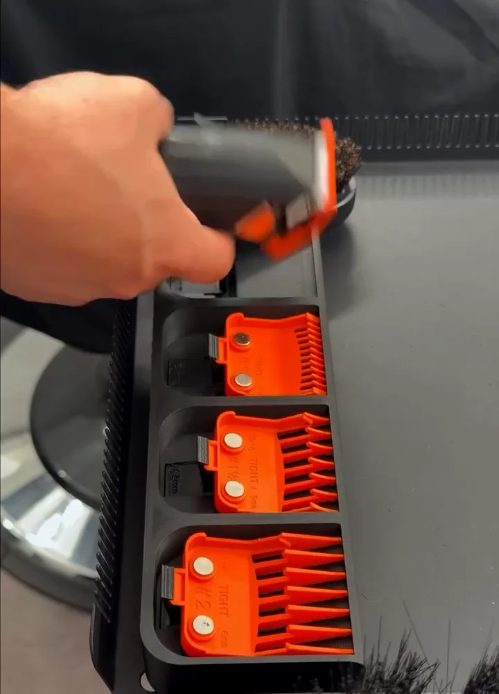 Une tondeuse repart du Support de Sabot avec son sabot clipsé ; les autres sabots orange attendent dans leurs emplacements